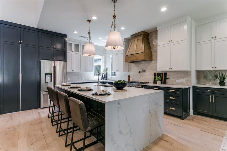 Kitchen featuring light hardwood / wood-style flooring, white cabinets, backsplash, and custom exhaust hood