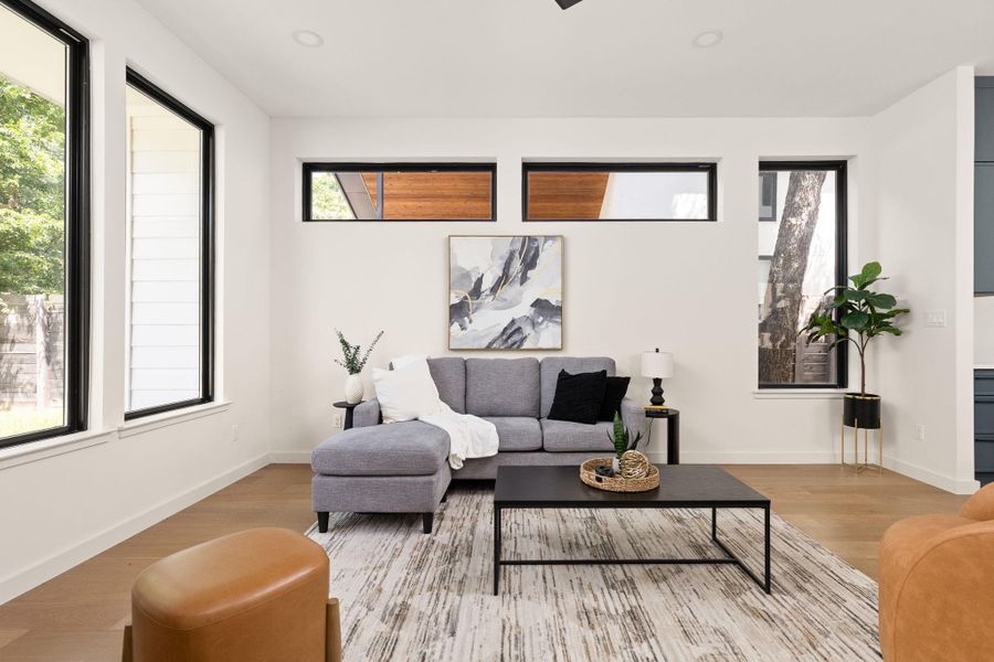 Clean lines and wood flooring define this comfortable living space, well-lit by multiple windows.