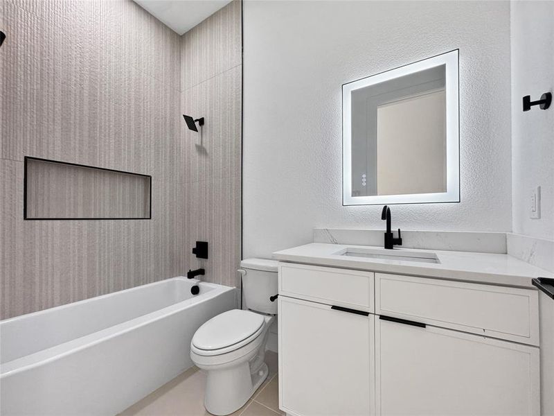 Full bathroom with bathing tub / shower combination, vanity, a textured wall, and light tile patterned flooring