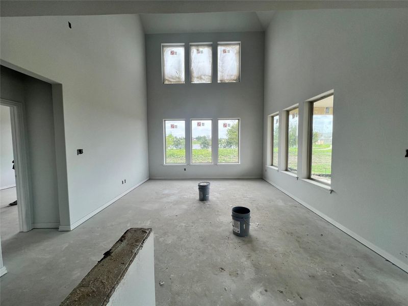 Unfurnished living room with a high ceiling and concrete floors
