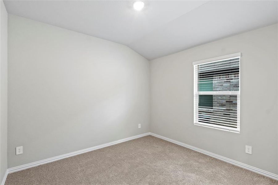 Carpeted spare room with lofted ceiling and baseboards Carpeted spare room with lofted ceiling and baseboards