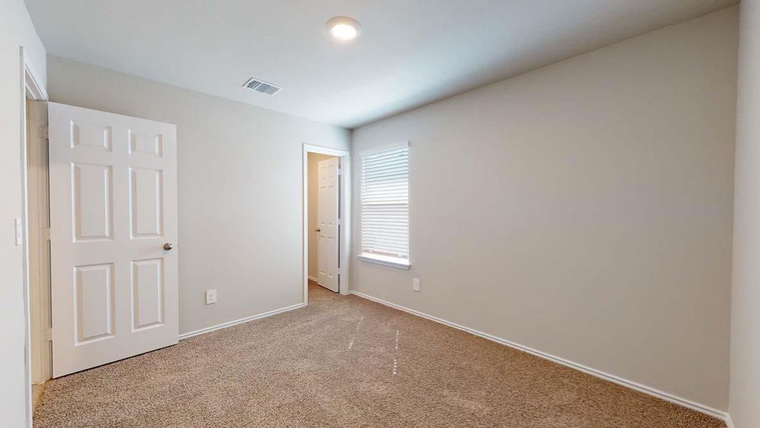 Neutral-toned room featuring light beige walls and a textured brown carpet