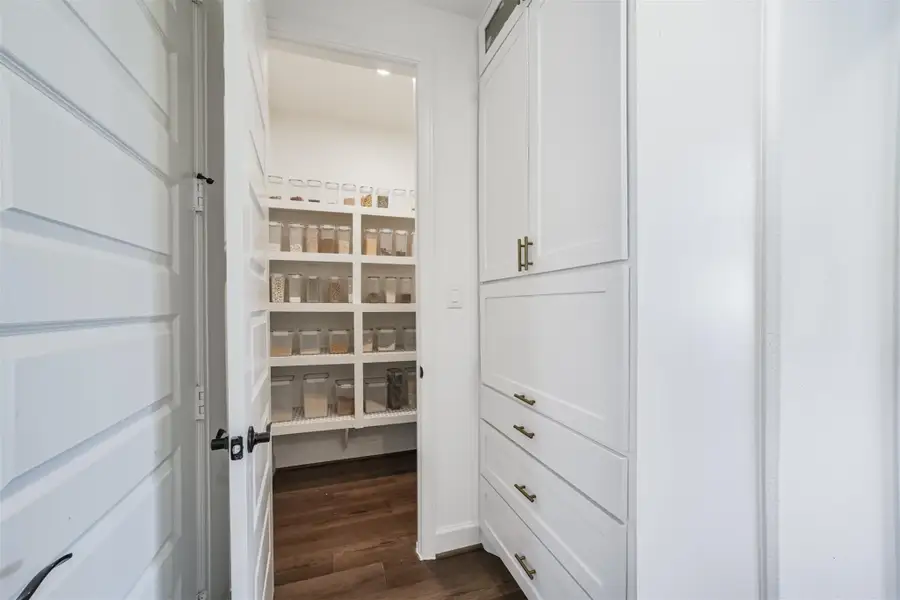 Spacious walk-in pantry featuring extensive shelving for optimal storage. Spacious walk-in pantry featuring extensive shelving for optimal storage.