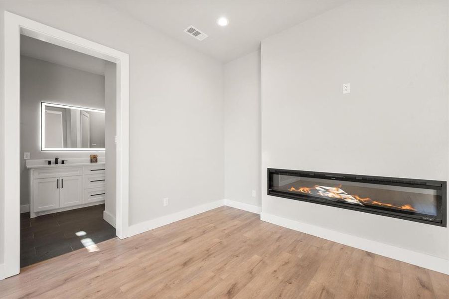 Master bedroom with fireplace, recessed lighting, ceiling and ensuite bathroom with barndoor entrance Master bedroom with fireplace, recessed lighting, ceiling and ensuite bathroom with barndoor entrance