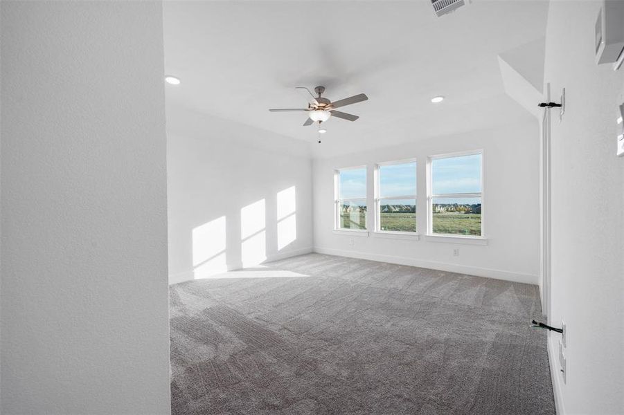 Carpeted empty room with ceiling fan