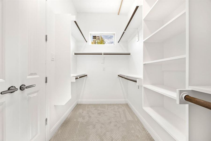 Walk in closet featuring light colored carpet