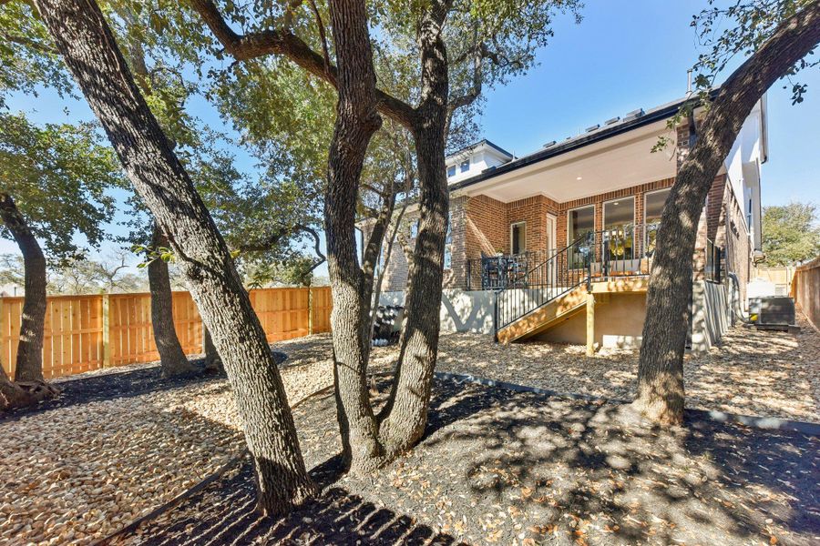Mature trees and a new wooden fence provide a private, verdant setting for this contemporary brick residence. Mature trees and a new wooden fence provide a private, verdant setting for this contemporary brick residence.