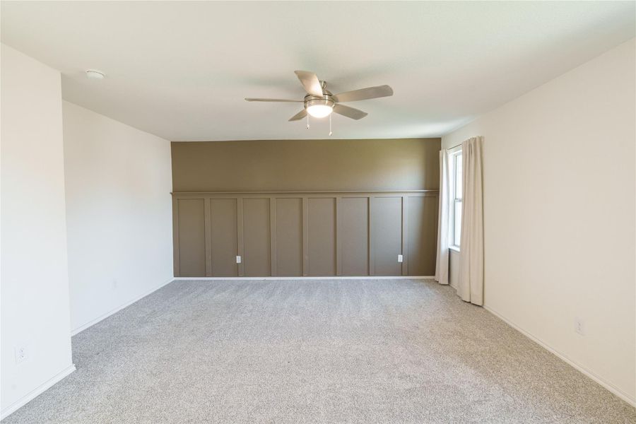An inviting room features a stylish accent wall with wainscoting and plush carpet underfoot. An inviting room features a stylish accent wall with wainscoting and plush carpet underfoot.