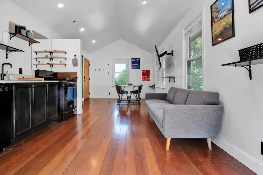 Living area with wood-type flooring and lofted ceiling