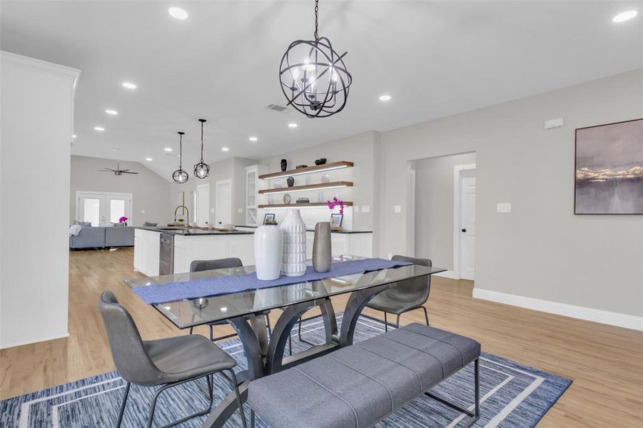 Dining space with a chandelier, light wood finished floors, recessed lighting, a ceiling fan, and vaulted ceiling