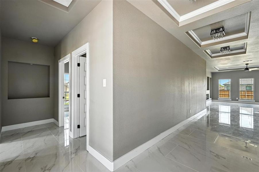 Hallway with marble finish flooring and ornamental molding Hallway with marble finish flooring and ornamental molding