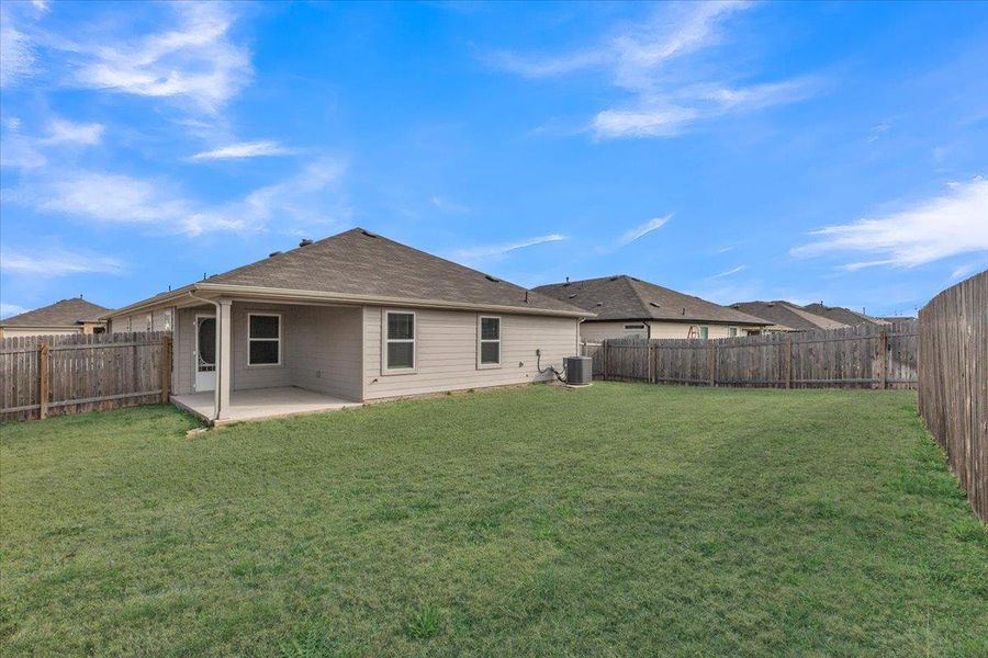 Rear view of house featuring a patio and a fenced backyard