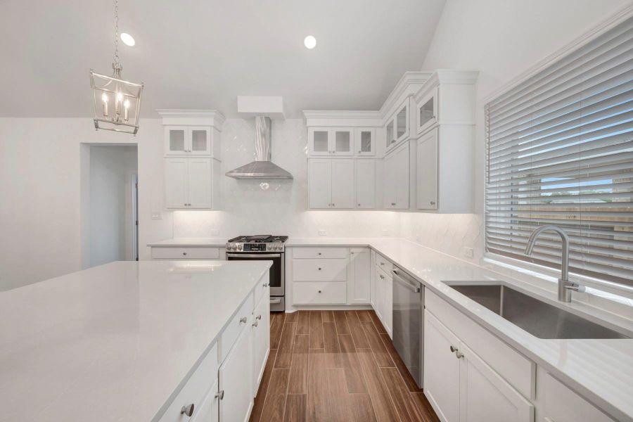 Gourmet kitchen with stacked cabinets and quartz counters (*Photo not of actual home and used for illustration purposes only.)
