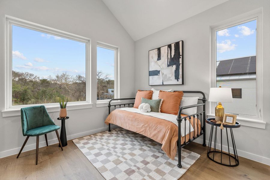 Bedroom featuring vaulted ceiling, wood finished floors, and baseboards