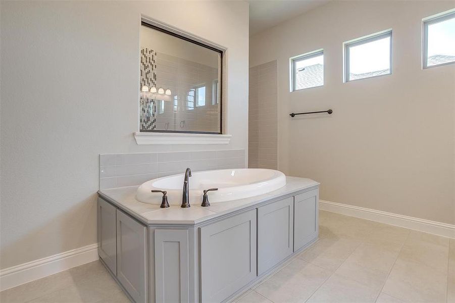 Bathroom with tile patterned floors, vanity, and a healthy amount of sunlight