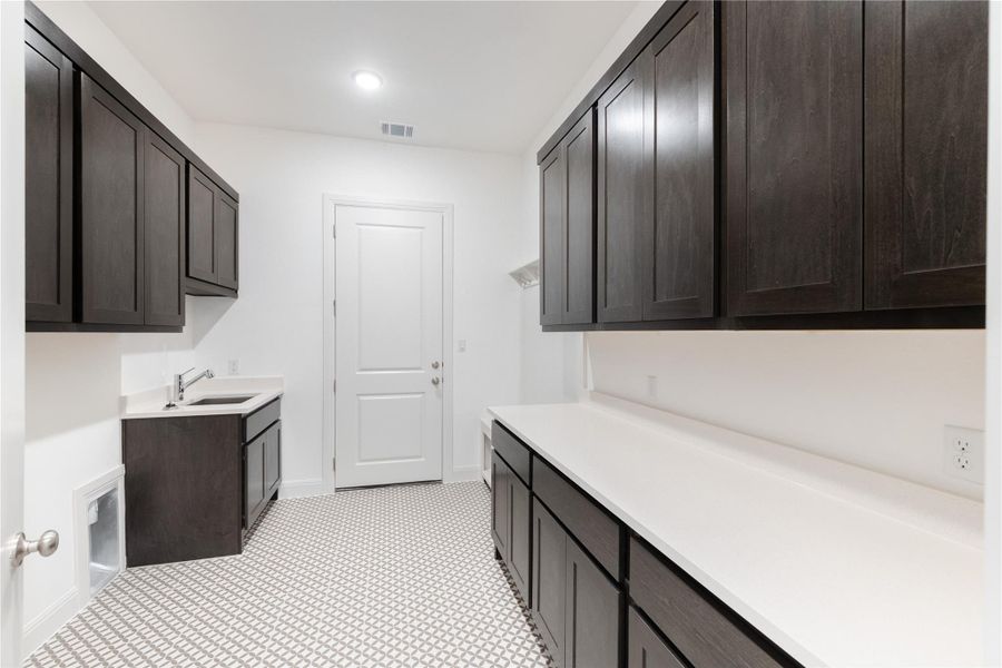 Laundry room with baseboards and a sink