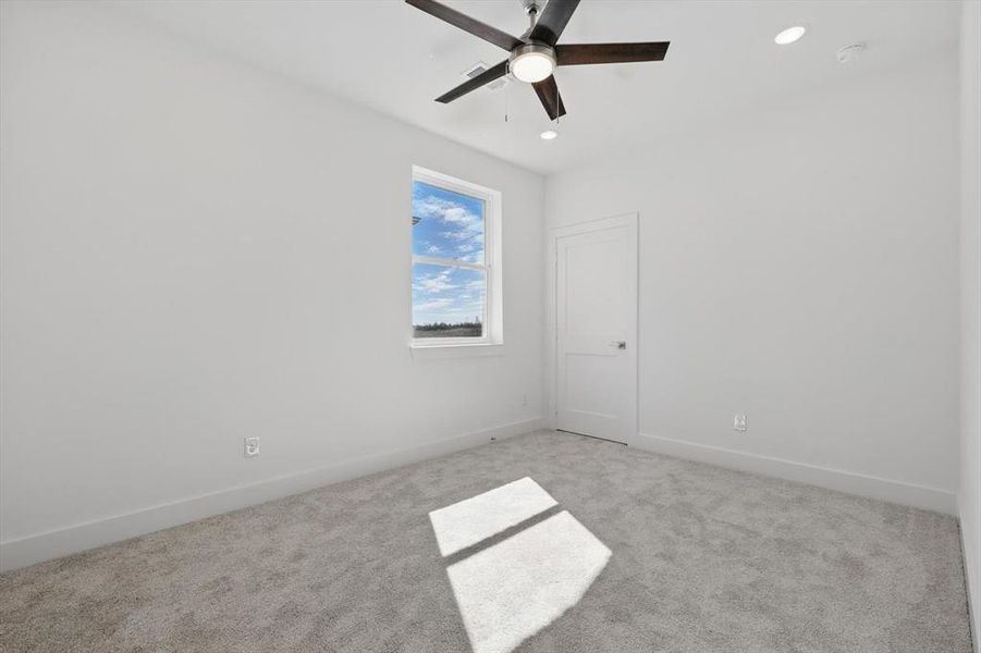 Spare room featuring baseboards, recessed lighting, and light colored carpet