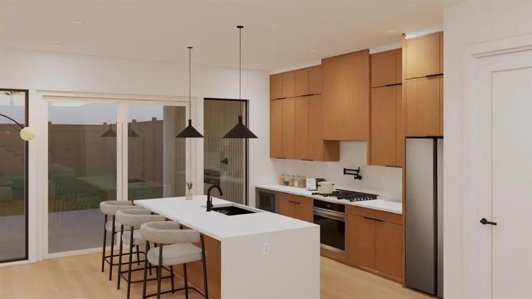 Kitchen featuring a kitchen bar, an island with sink, stainless steel fridge, and light wood-style flooring