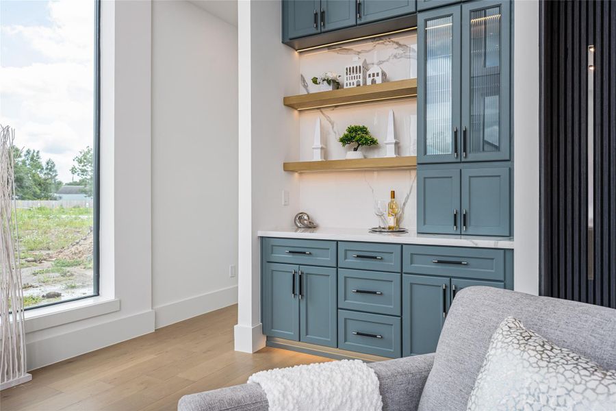 A built-in dry bar or art alcove with generous storage adds a custom touch and an element of versatility to the living area A built-in dry bar or art alcove with generous storage adds a custom touch and an element of versatility to the living area