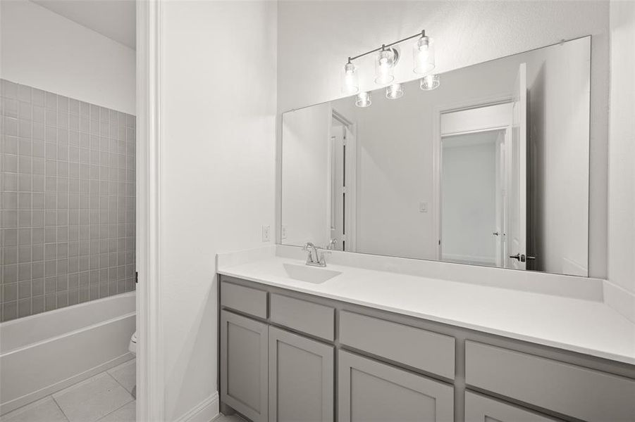 Bathroom featuring vanity, tile patterned floors, and shower / bath combination Bathroom featuring vanity, tile patterned floors, and shower / bath combination