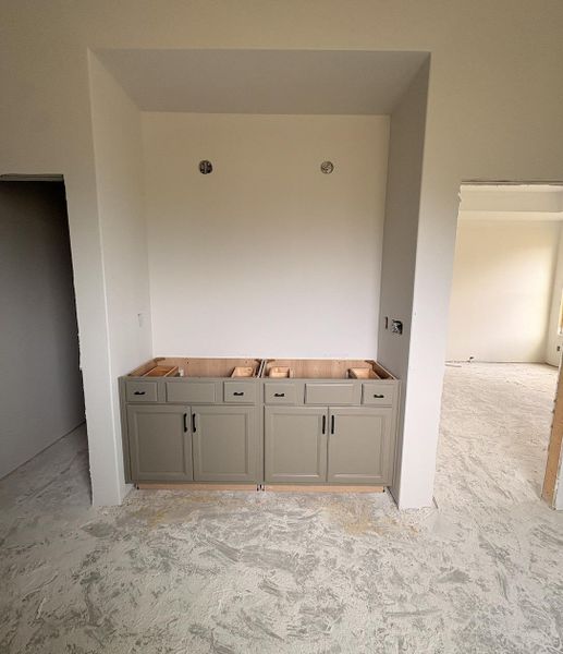 Built-in cabinetry featuring a neutral finish and black hardware, designed for a double vanity installation Built-in cabinetry featuring a neutral finish and black hardware, designed for a double vanity installation