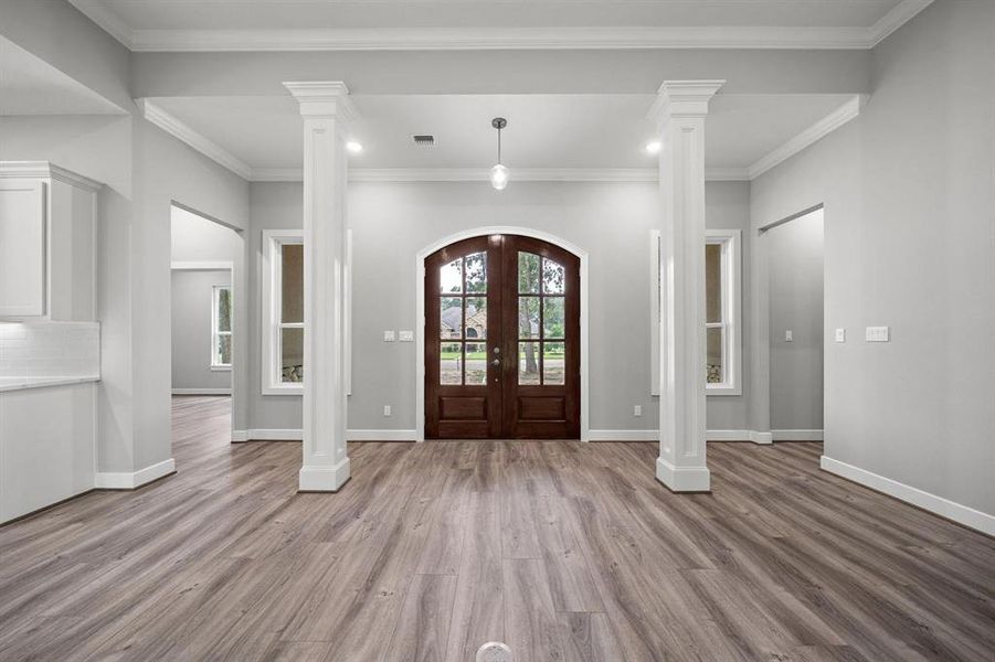 Detailed columns accentuate arched 8 ft doors in front entry.