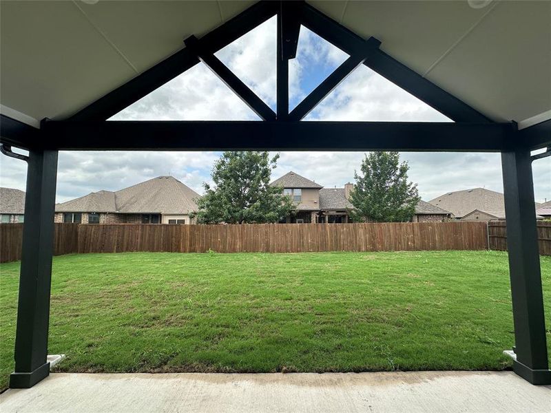 Covered rear patio. View of yard