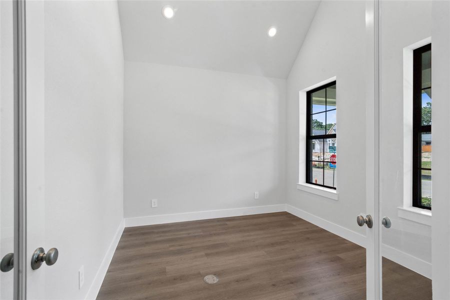 Tucked peacefully in the front of the home is this Study. The Study offers a quiet workspace with LVP flooring, high ceilings, double French doors for added privacy, large windows, and custom paint for a polished finish.