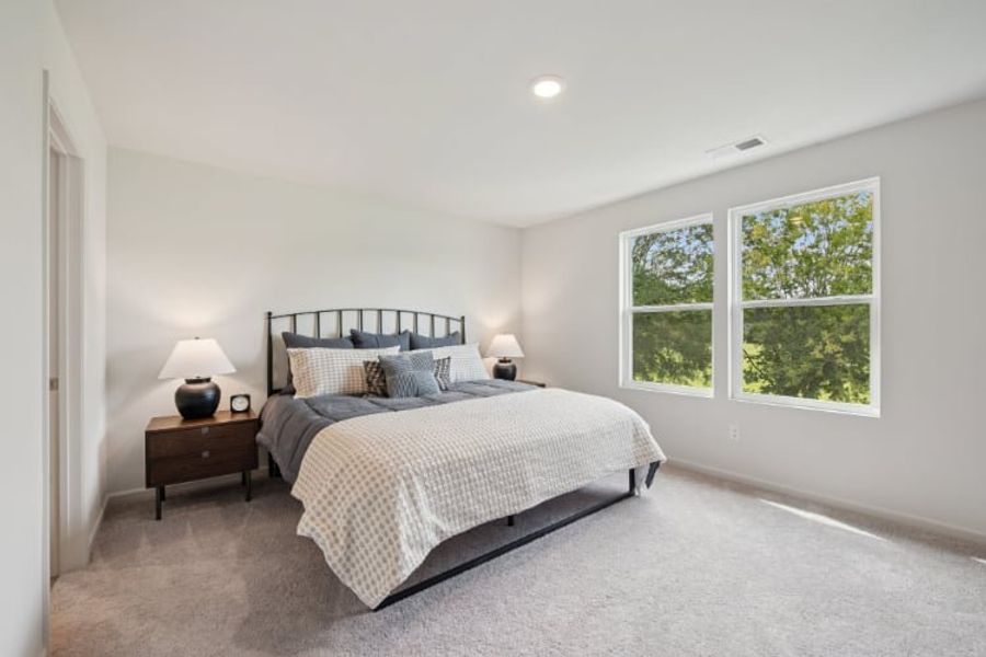 A bedroom with a bed and a window.