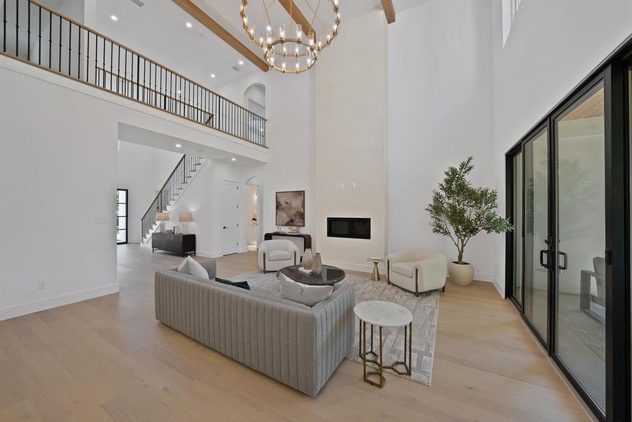 Open-concept living space featuring high ceilings, wood-finish flooring, and exposed ceiling beams