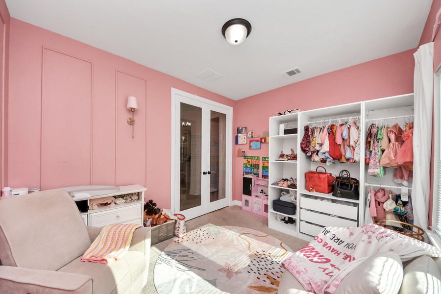 This cozy room features soft pink walls, a plush chair, and ample storage with open shelving for clothes and accessories. Bright and inviting, perfect for a child's bedroom or playroom. This cozy room features soft pink walls, a plush chair, and ample storage with open shelving for clothes and accessories. Bright and inviting, perfect for a child's bedroom or playroom.