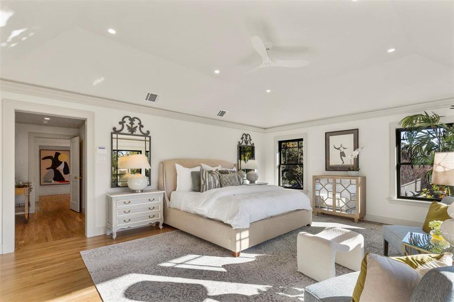 Bedroom with hardwood / wood-style floors, ornamental molding, ceiling fan, and a raised ceiling