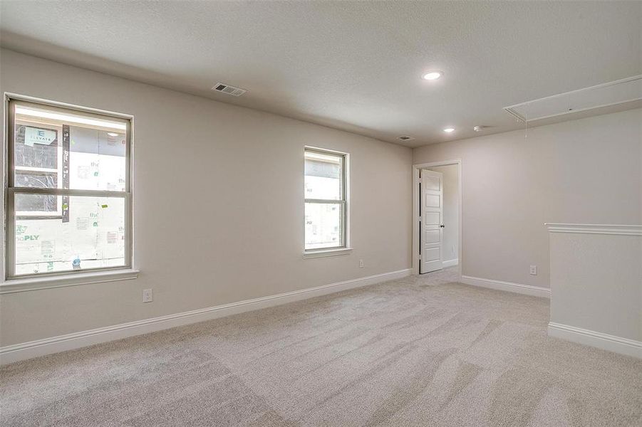 Unfurnished room with attic access, light carpet, and recessed lighting