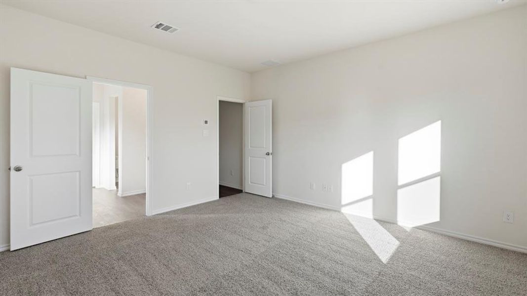 Unfurnished bedroom featuring light colored carpet and baseboards