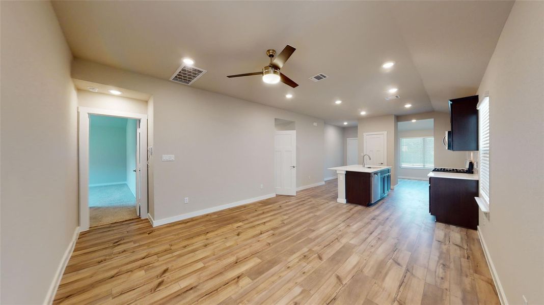 An open concept living area showcases beautiful flooring and an integrated kitchen with an island. An open concept living area showcases beautiful flooring and an integrated kitchen with an island.