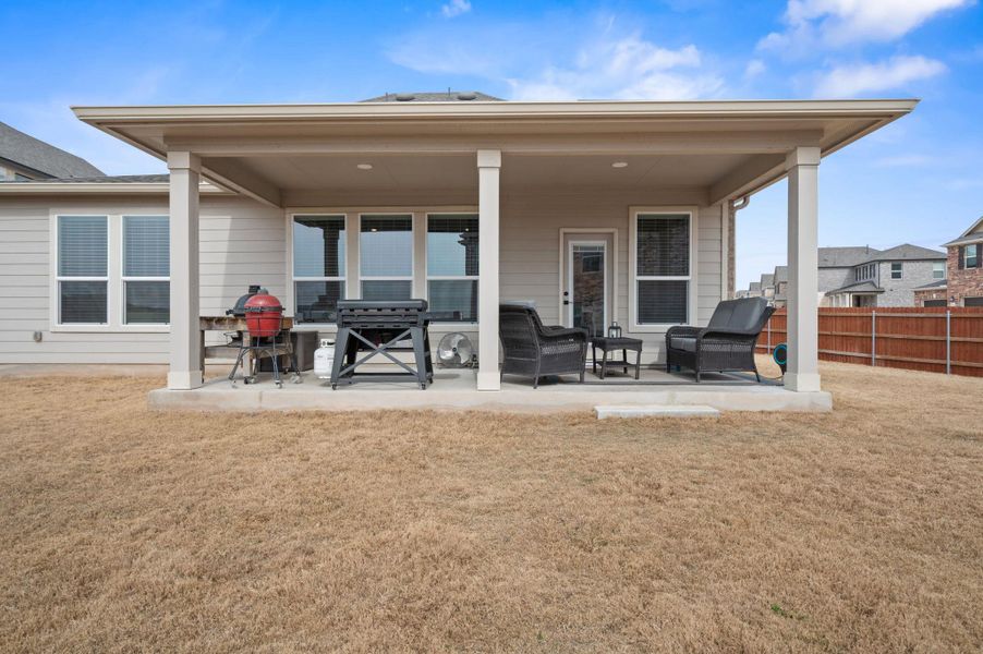 Rear view of property featuring a lawn and a patio area