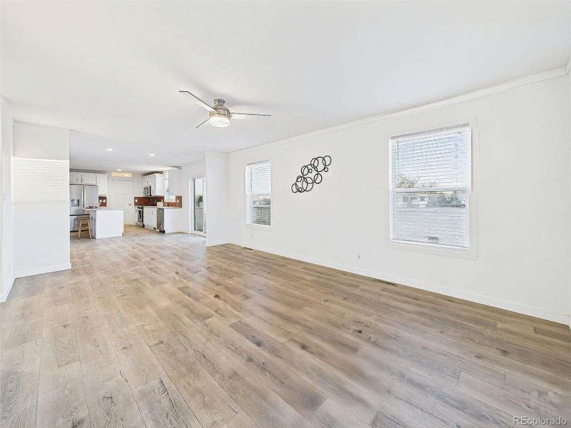 Living Room Wide plank floors and a bright, neutral palette enhance the sense of space in this open-concept living and kitchen area.