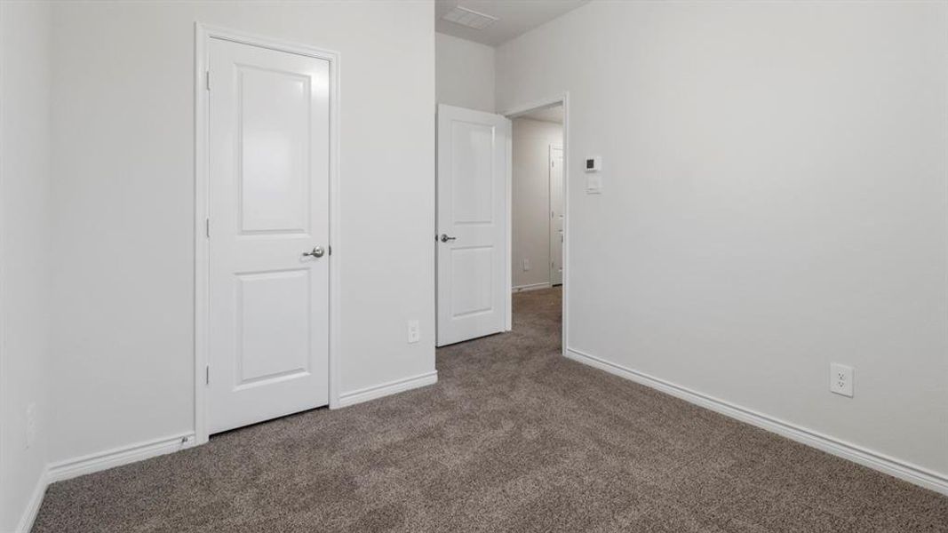 Neutral tone interior with plush gray carpeting, white baseboards, and white walls