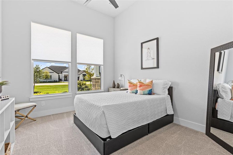 Bedroom with light colored carpet and a ceiling fan