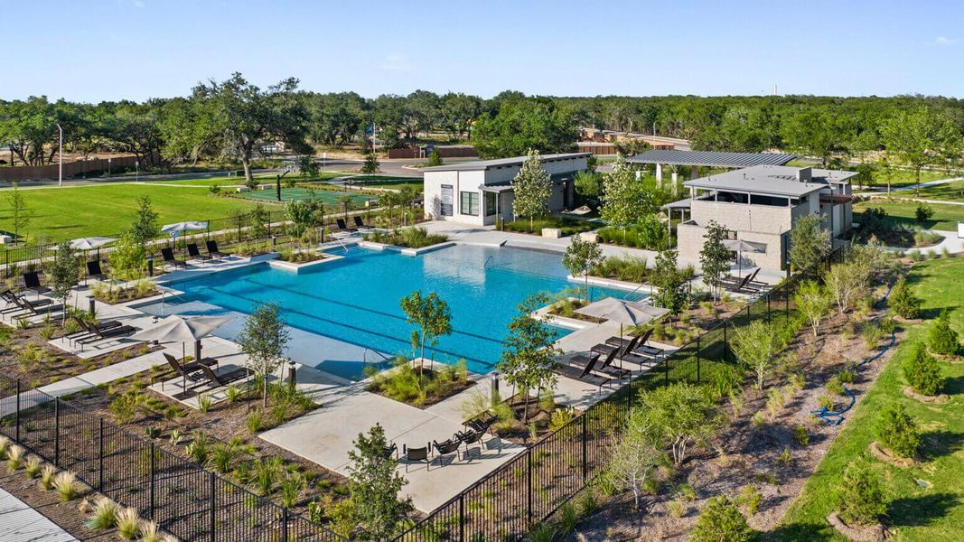 Community pool featuring a patio area and view of wooded area