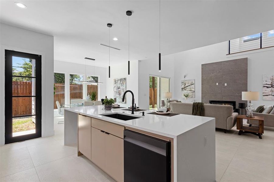 Kitchen featuring a kitchen island with sink, sink, a tiled fireplace, and light tile patterned floors