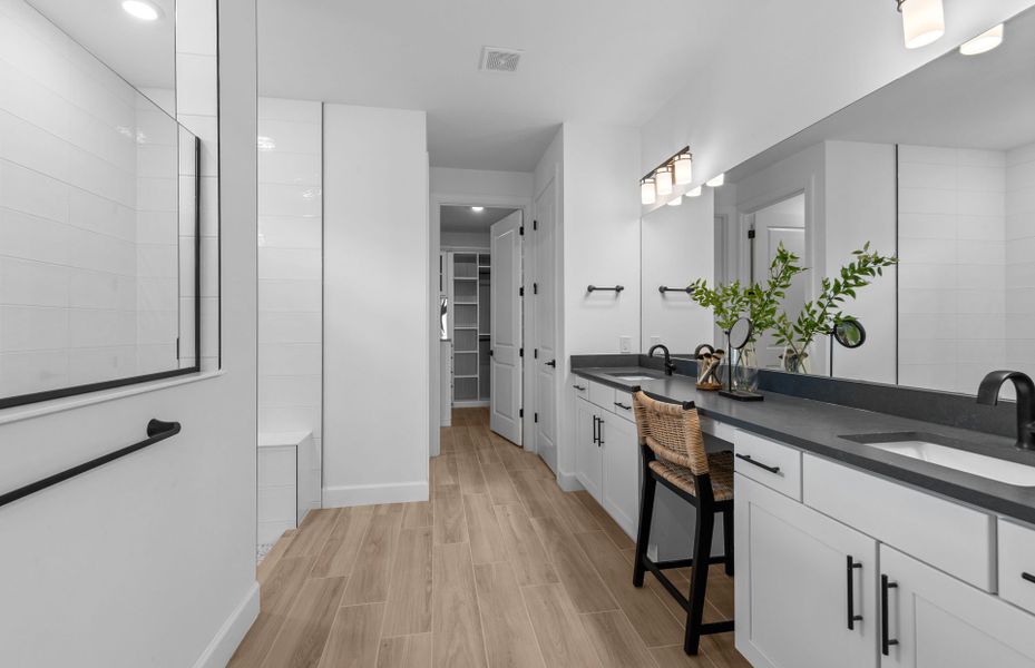 Owner's bathroom with dual sink vanity and walk-in shower