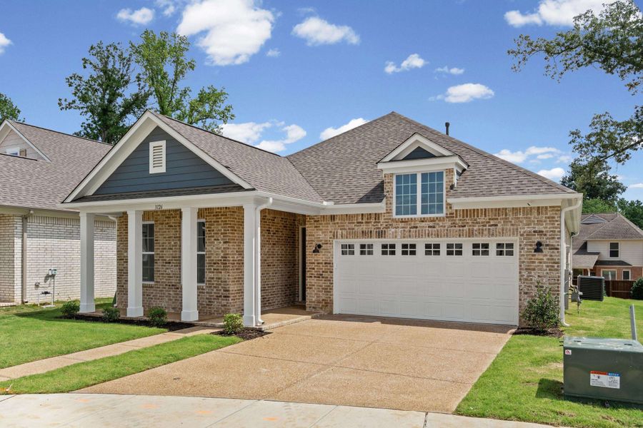 Brick exterior with a gabled roofline, featuring a covered entry porch with white columns Brick exterior with a gabled roofline, featuring a covered entry porch with white columns