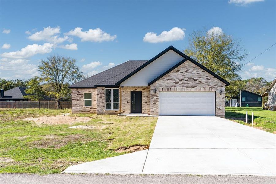 View of front of house featuring a front yard and a garage