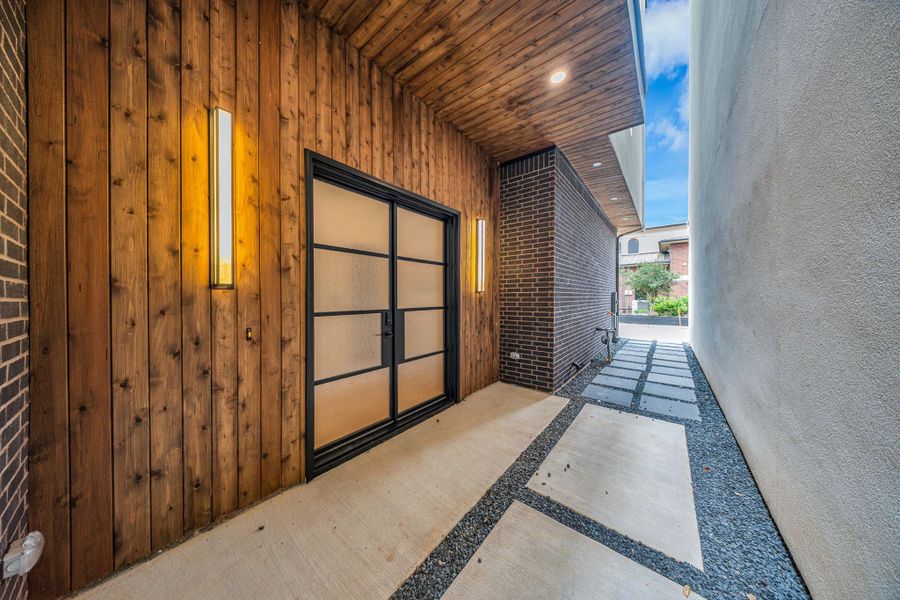 Modern entryway with a wooden accent wall and sleek frosted glass door. The space combines contemporary design with warm lighting for a welcoming feel. Modern entryway with a wooden accent wall and sleek frosted glass door. The space combines contemporary design with warm lighting for a welcoming feel.