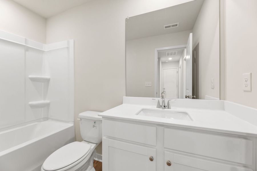 A bathroom with a tub sink and toilet.