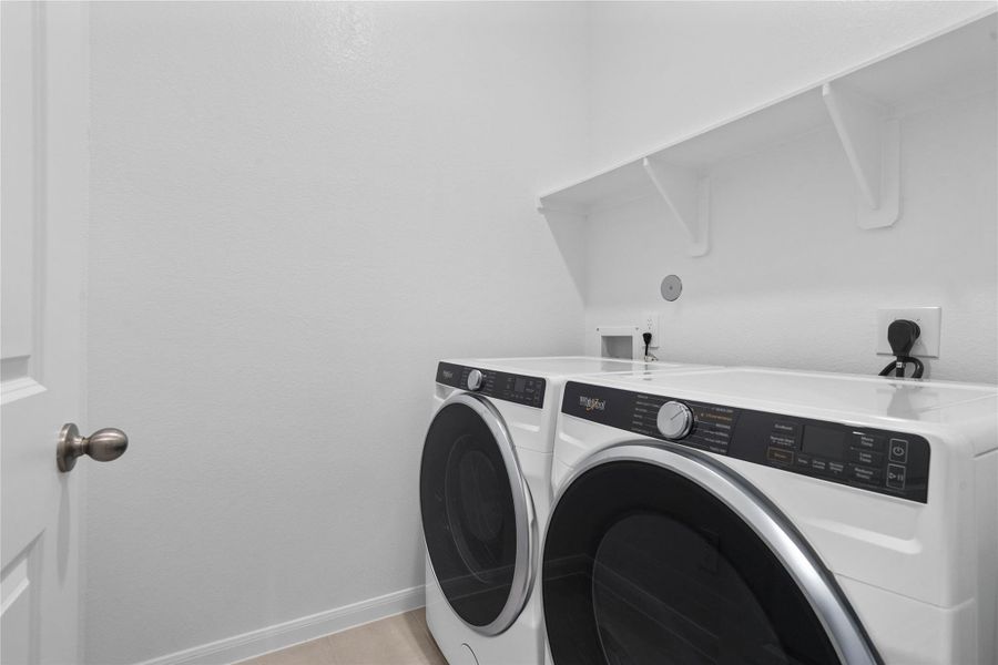 This dedicated laundry room comes equipped with a washer and dryer set, ready for immediate use.