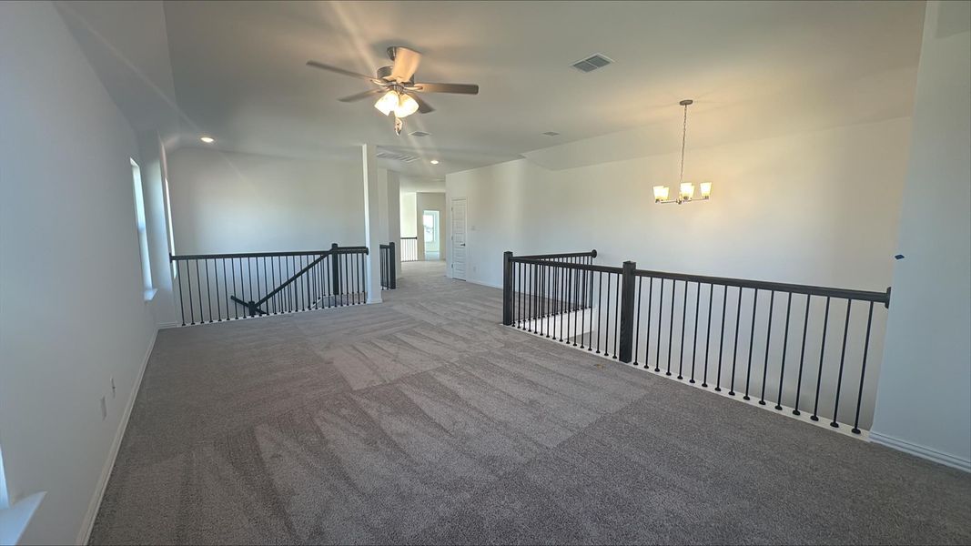 Carpeted empty room featuring recessed lighting, a ceiling fan, and a chandelier