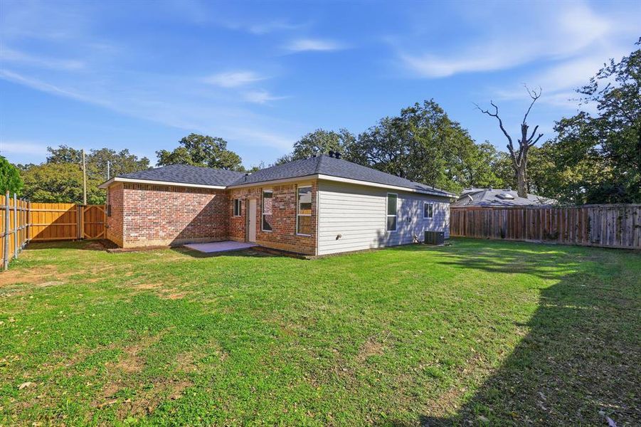 Rear view of house featuring a fenced backyard, a patio, brick siding, and a shingled roof