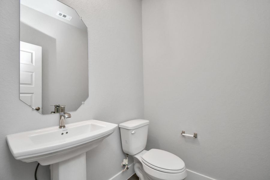 Sophisticated half bathroom adorned with contemporary finishes. Sample photo of completed home with similar plan. As built color and selections will vary. Sophisticated half bathroom adorned with contemporary finishes. Sample photo of completed home with similar plan. As built color and selections will vary.